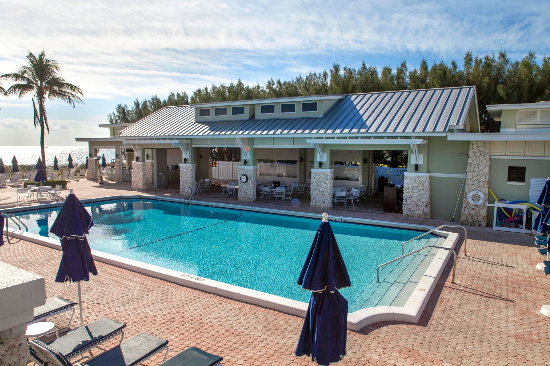 Beach club with a pool, brickwork, and ocean views in Delray Beach, FL.