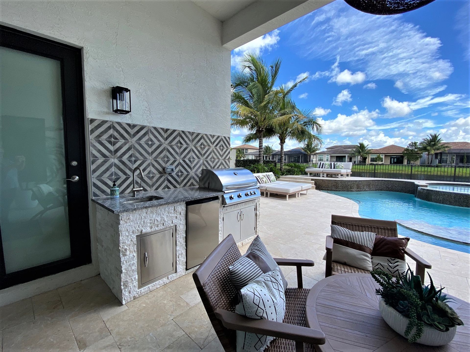 Modern outdoor kitchen with grill and bar seating in Boca Raton, FL.