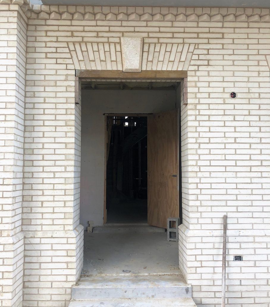 Entrance of a residential building with detailed brickwork in Boca Raton, FL.