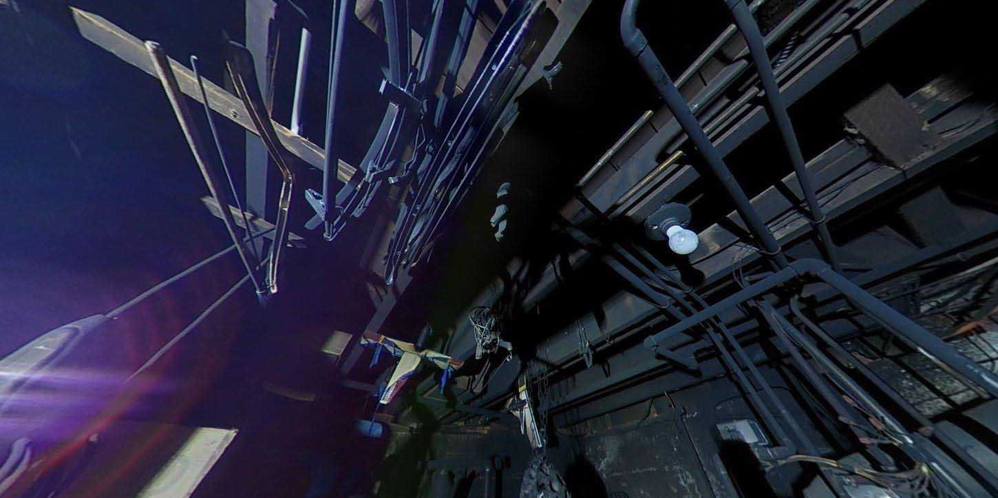 Low-angle view of a dark, unfinished basement ceiling with exposed wooden beams, pipes, and hanging electrical wires.