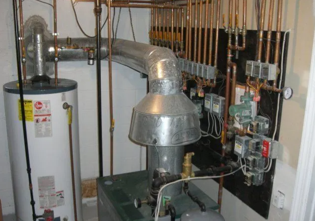 Water heater and furnace with copper pipes in a basement setting.