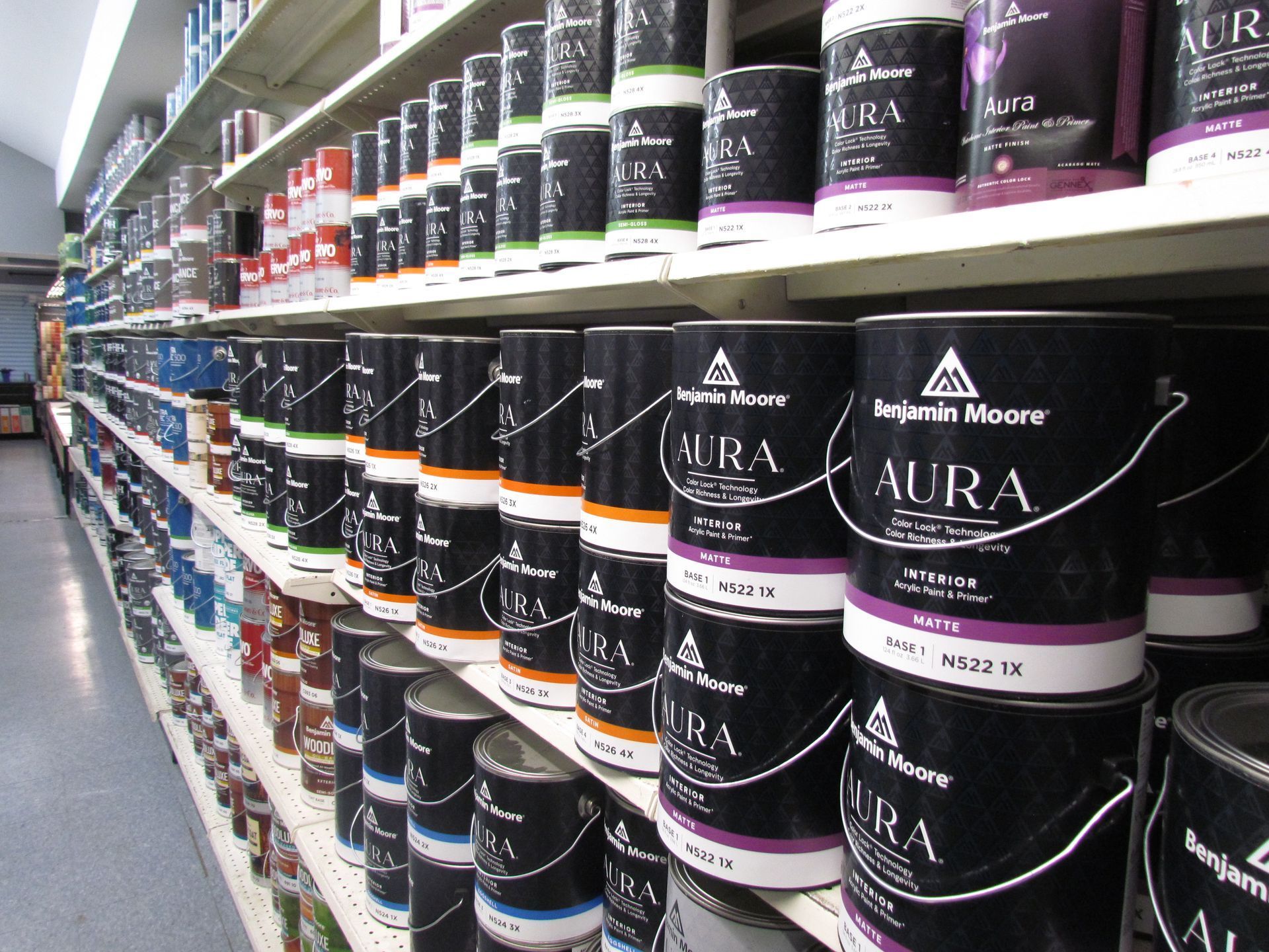 Rows of paint cans on store shelves, many labeled 