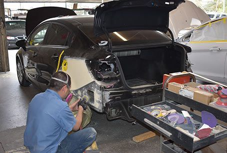 A man is working on a car in a garage.