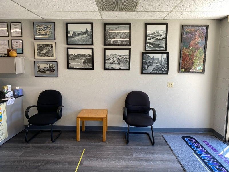 A waiting room with two chairs and pictures on the wall