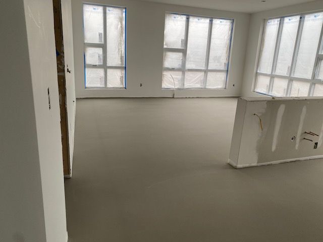 a large empty room with a lot of windows and a concrete floor
