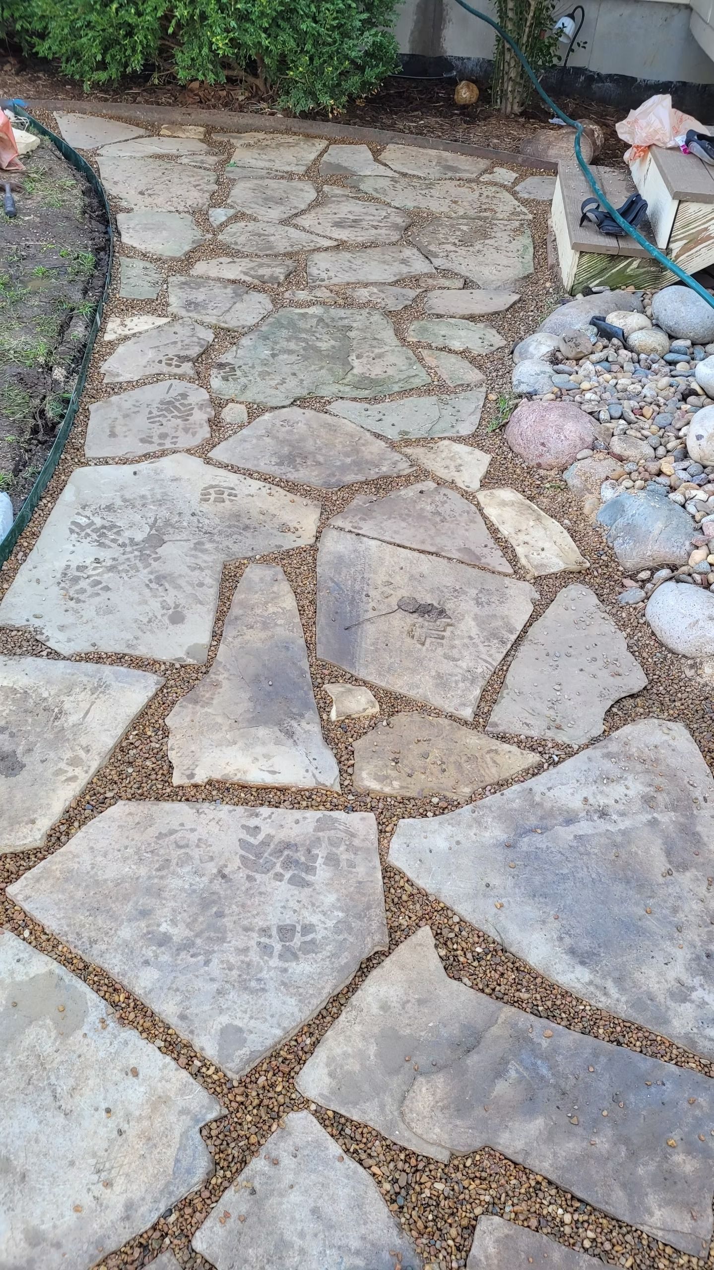Stone pathway with gravel in between, in a garden.