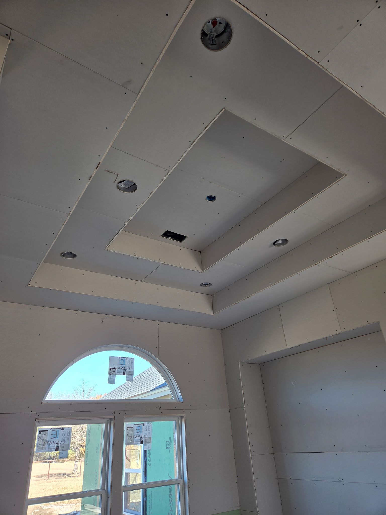 White drywall ceiling with recessed lighting and rectangular decorative elements.