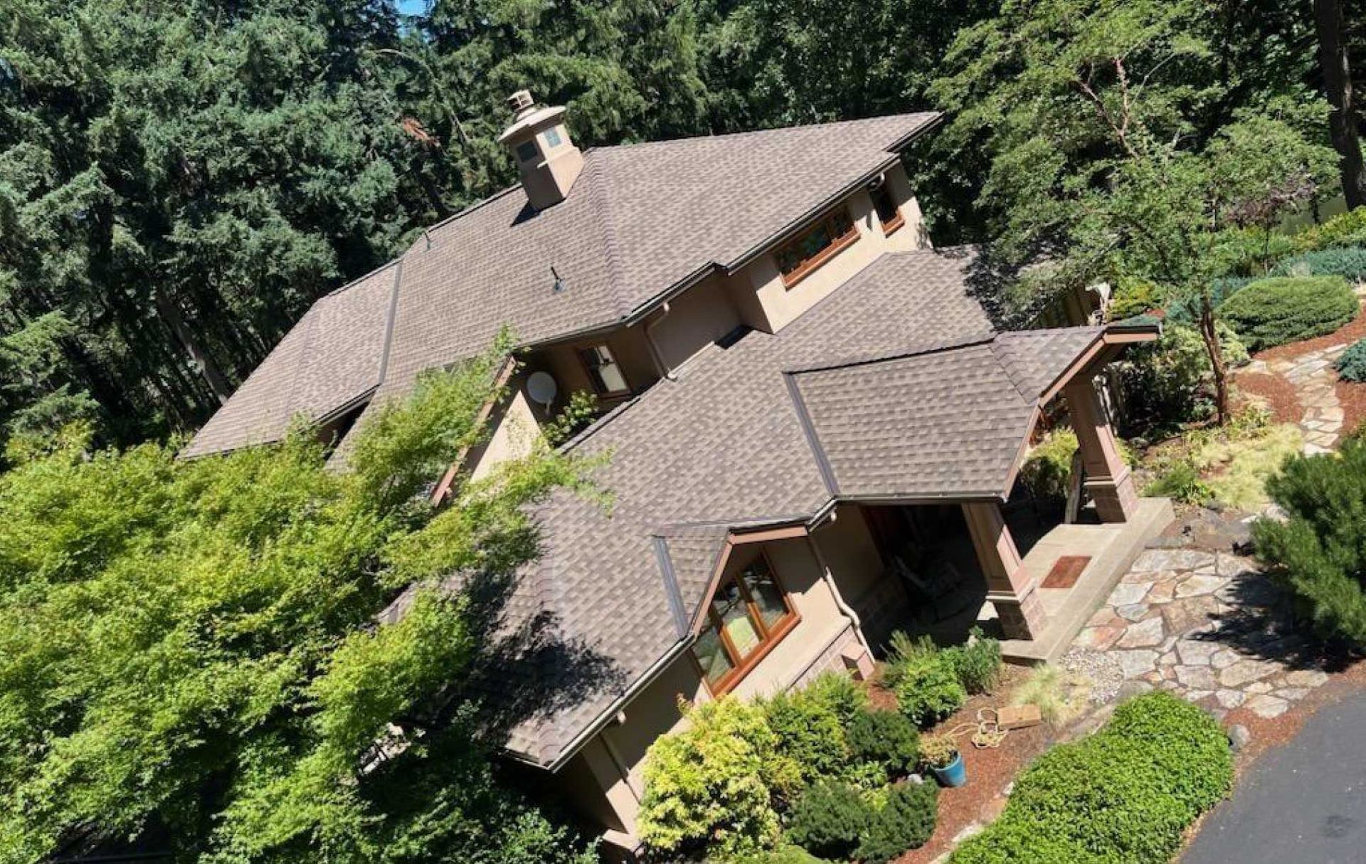 Skylights installed on a brown roof, varying in size and shape with metal frames. A level is partially visible.