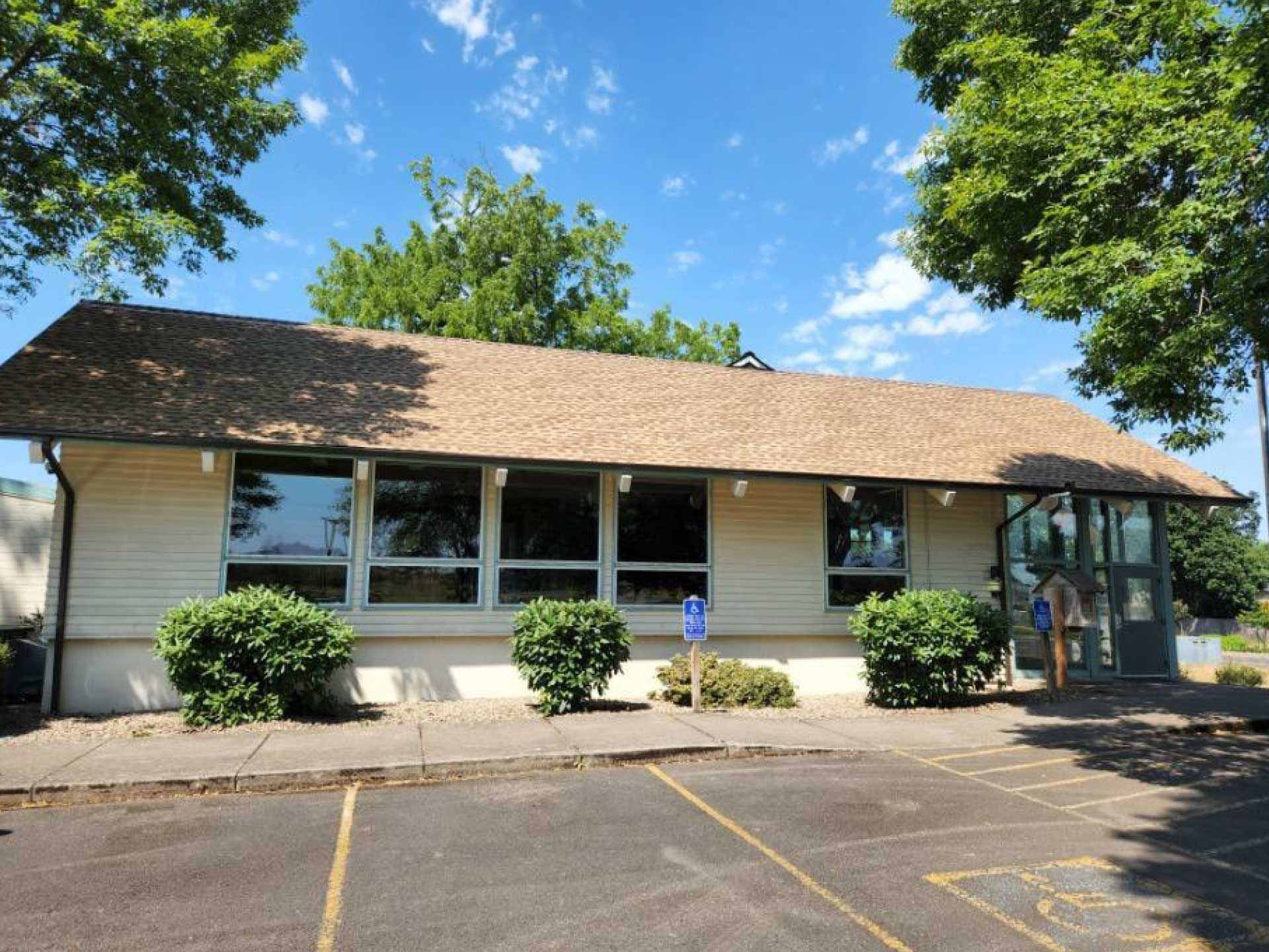low, tan-roofed building with large windows