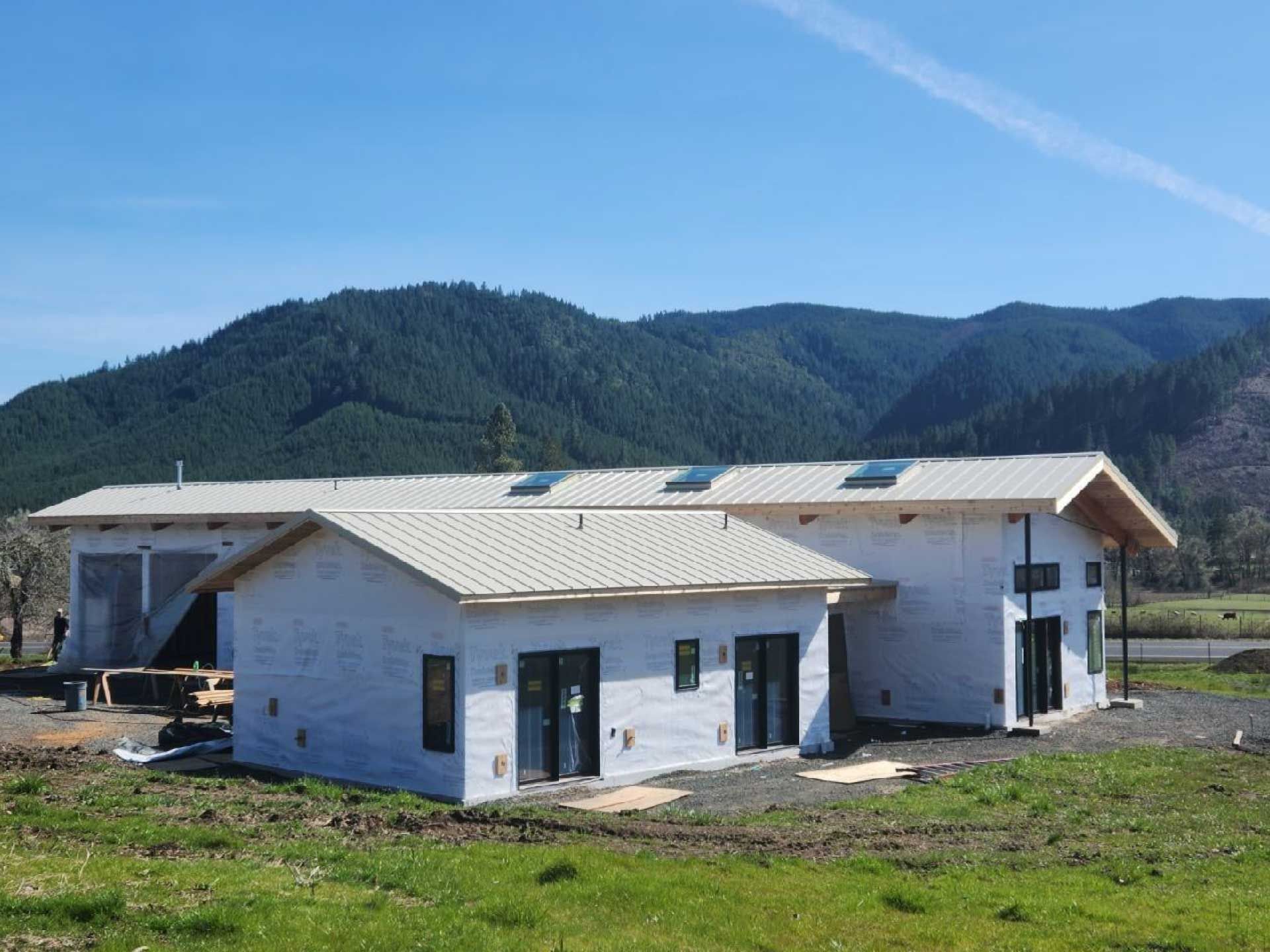 newly constructed buildings with dark windows under a blue sky, mountains in background