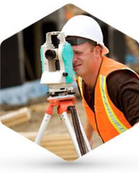 A land surveyor working with a theodolite at construction site