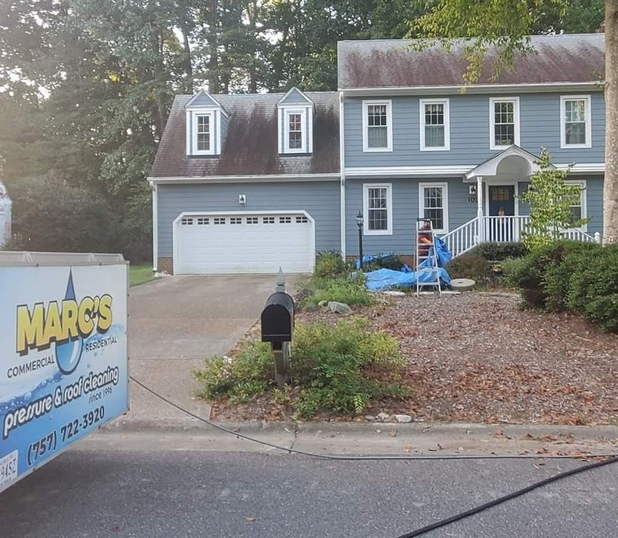 Before photo of a blue house with a mailbox and a sign