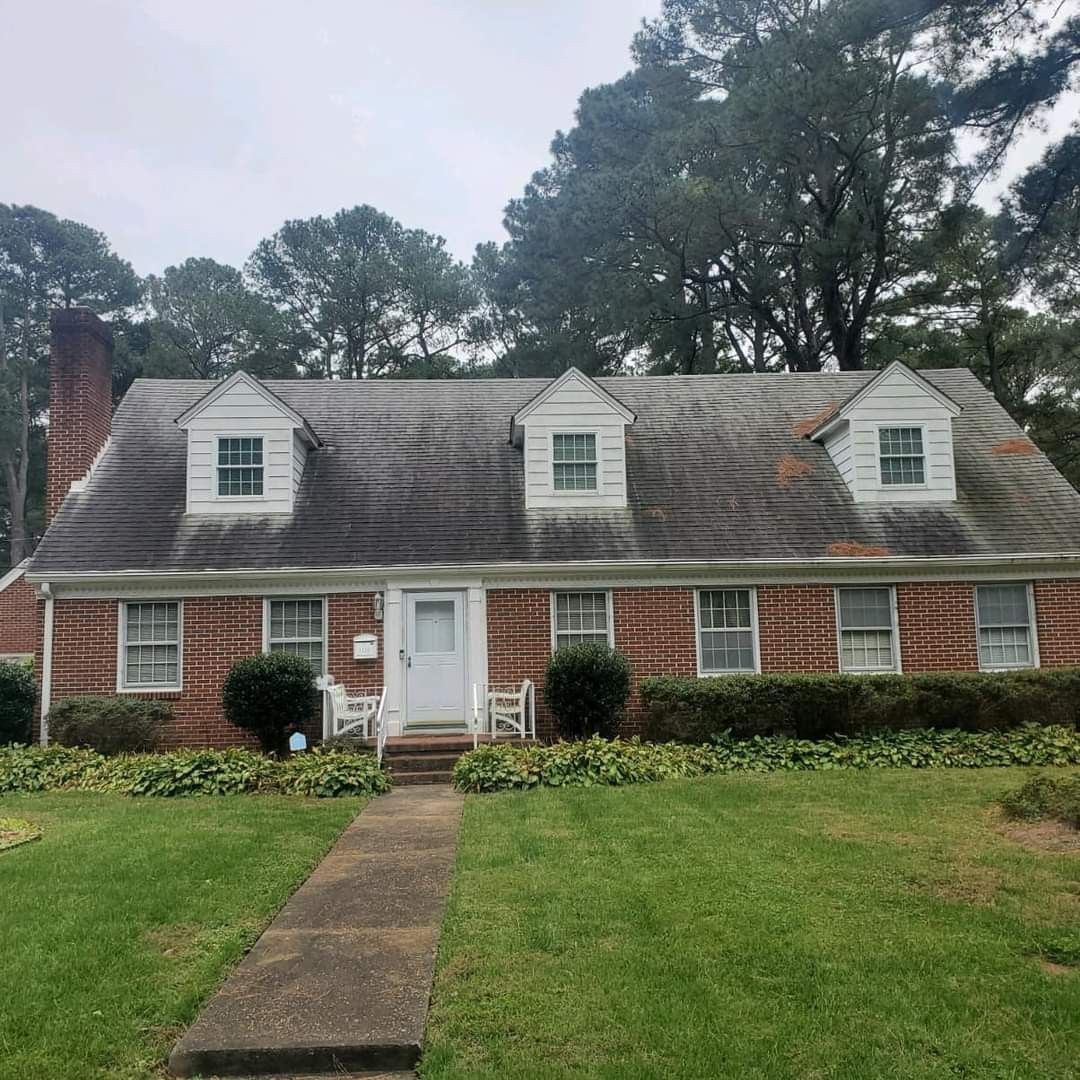 Before photo of brick house with a white roof and a walkway