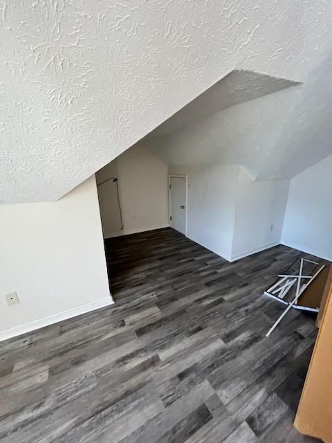 an empty room with a wooden floor and white walls