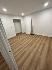 an empty room with vinyl floors and white walls