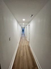 a long hallway with vinyl floors and white walls in a house