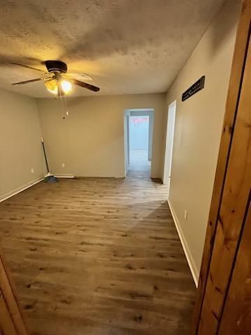 a living room with vinyl floors and a ceiling fan