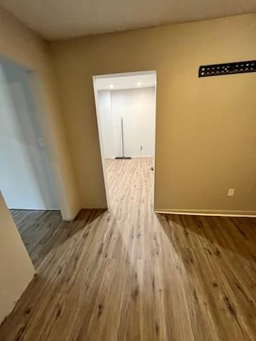 a room with vinyl floors and a doorway leading to another room