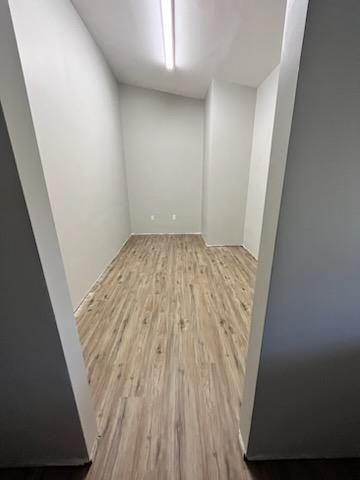 an empty room with vinyl floors and white walls