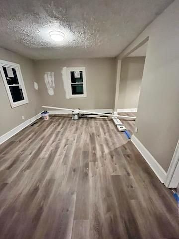 an empty room with vinyl floors and a window