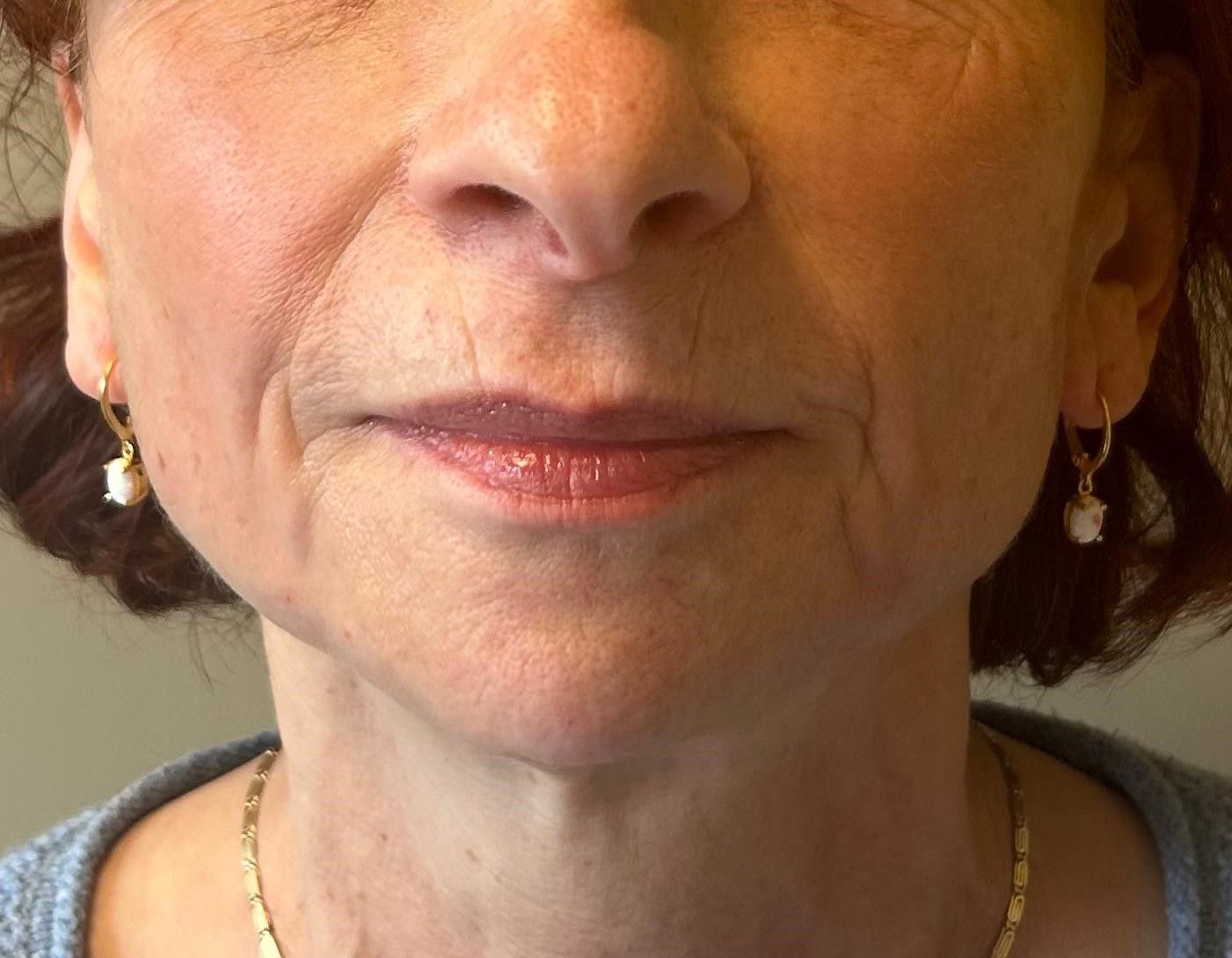 A close up of a woman 's face with a necklace and earrings.