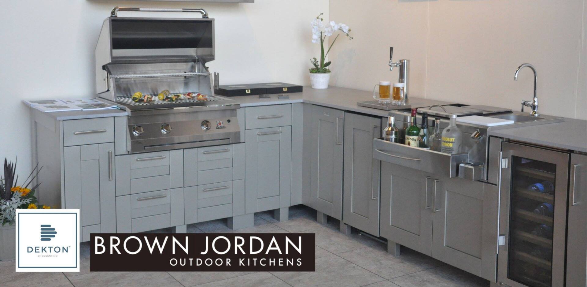 A brown jordan outdoor kitchen with gray cabinets and stainless steel appliances