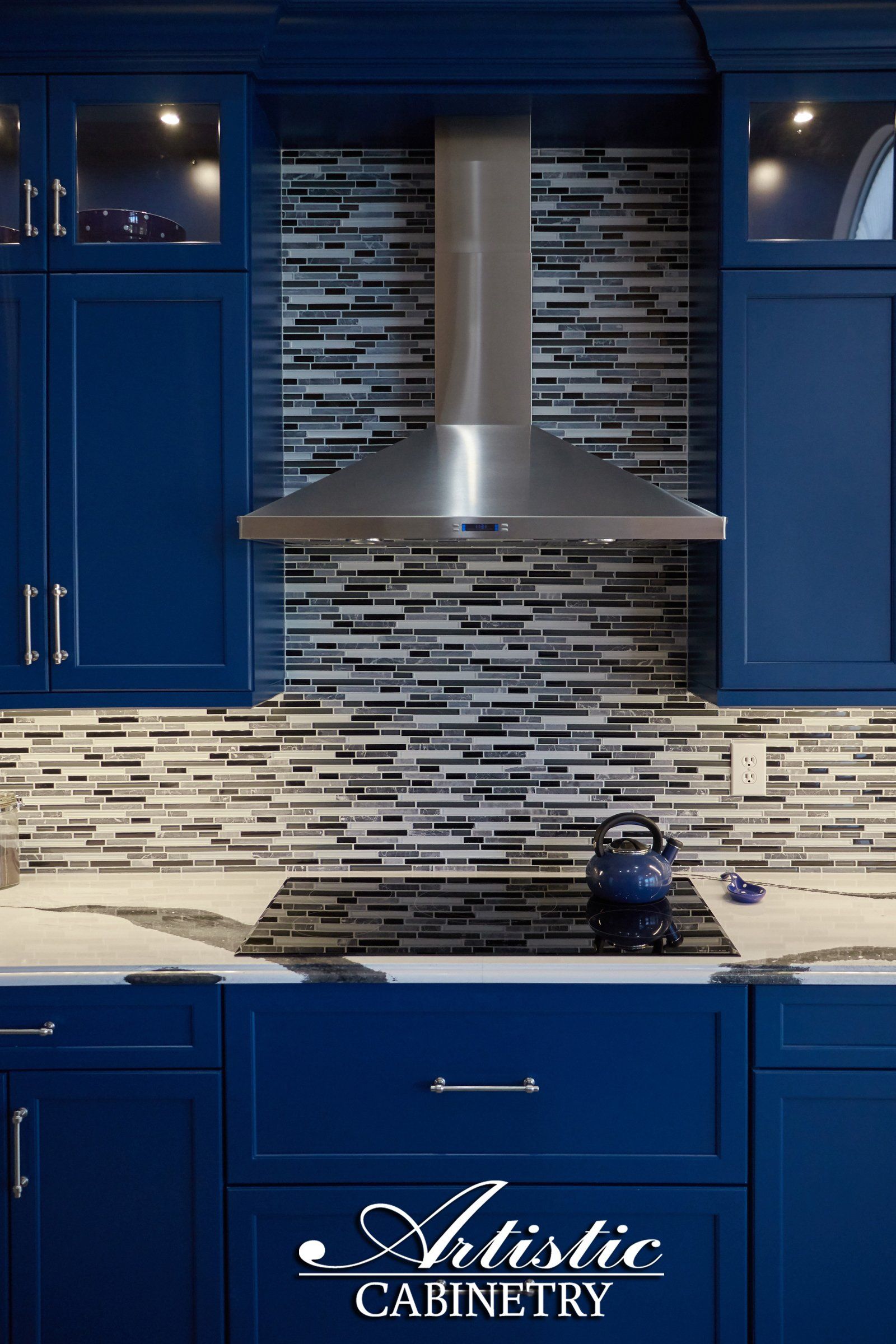 A kitchen with blue cabinets and stainless steel appliances from artistic cabinetry