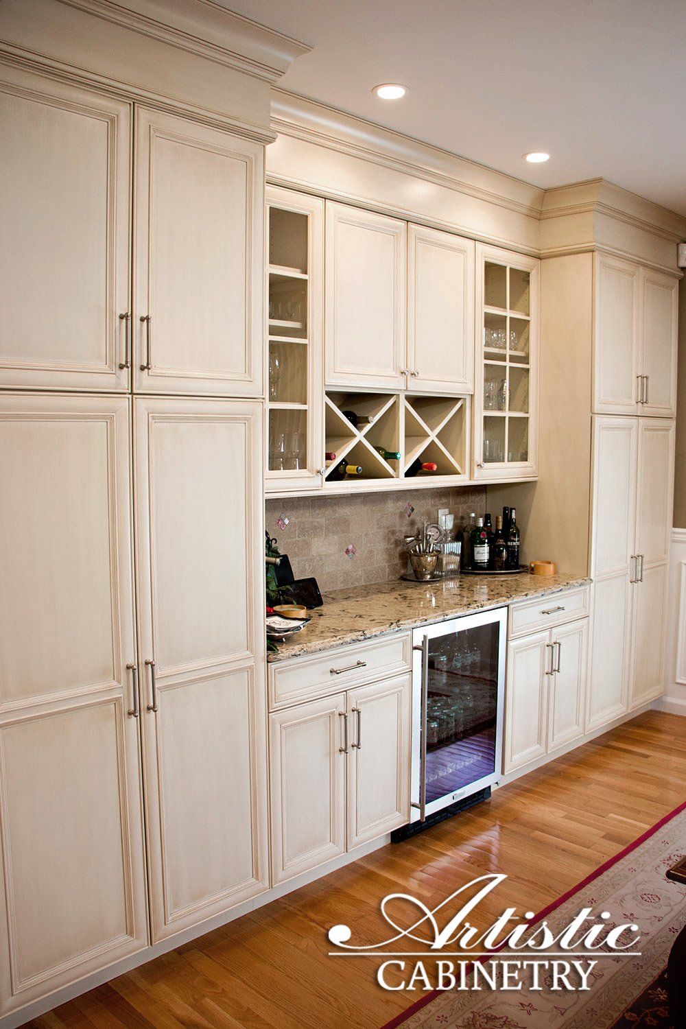 A kitchen with white cabinets , granite counter tops , and a wine cooler.