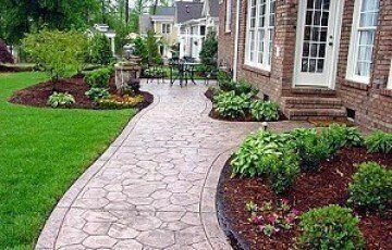 A brick house with a patio and a walkway leading to it.