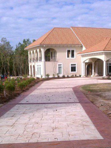 A large house with a brick driveway leading to it.