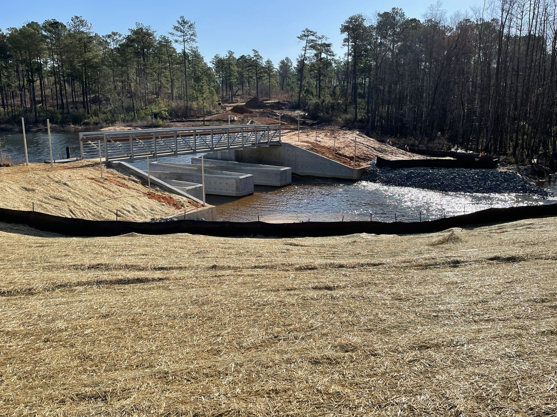A bridge over a body of water with trees in the background