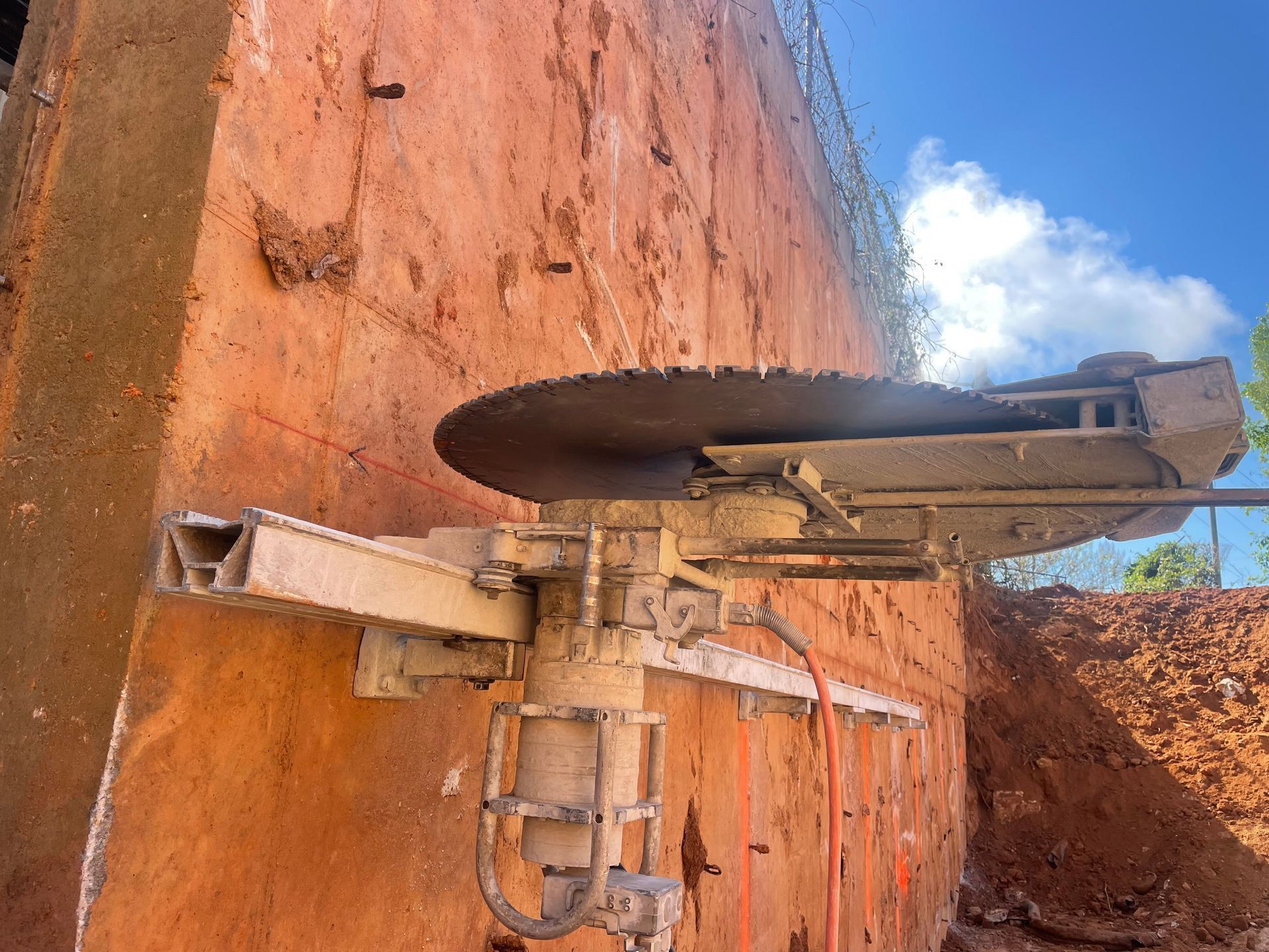 A machine is cutting a hole in a wall.