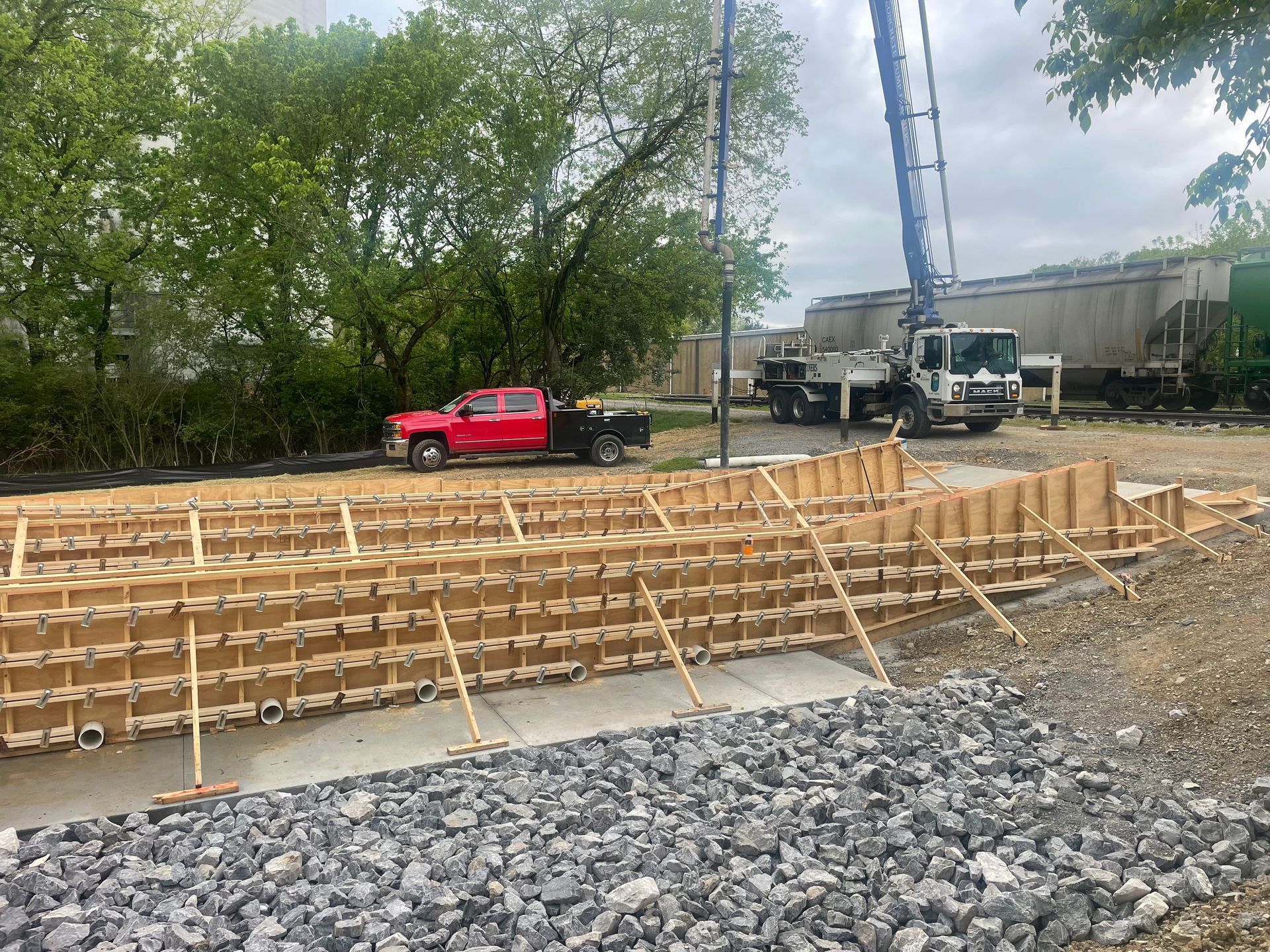 A red truck is parked in front of a construction site.