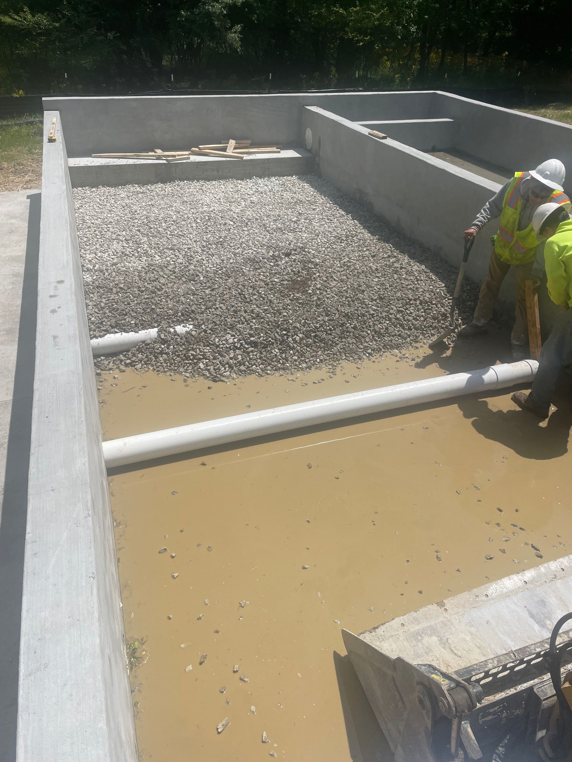 A group of construction workers are working in a muddy area.