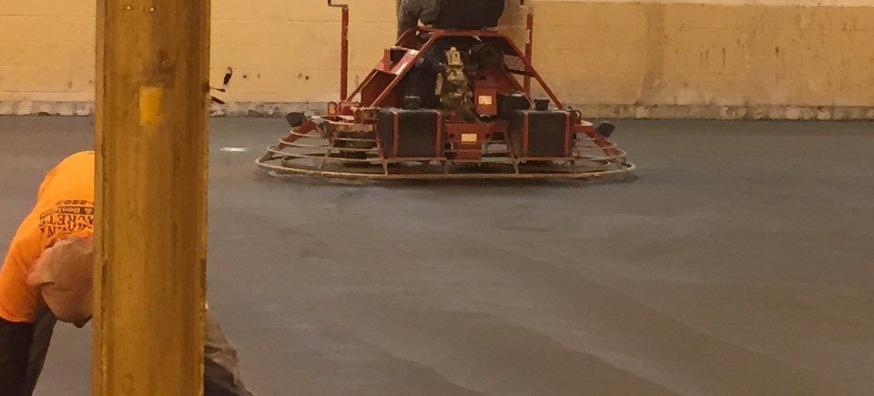A man is riding a machine on a concrete floor.
