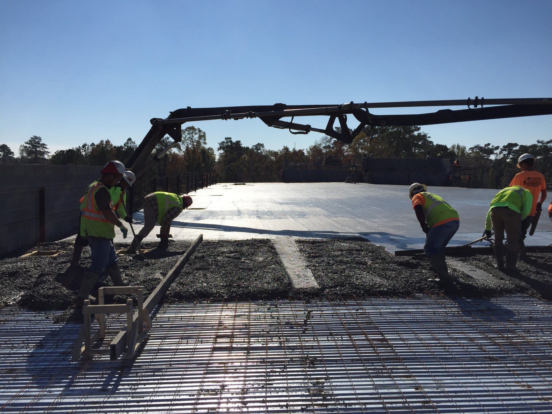 A group of construction workers are working on a concrete floor.