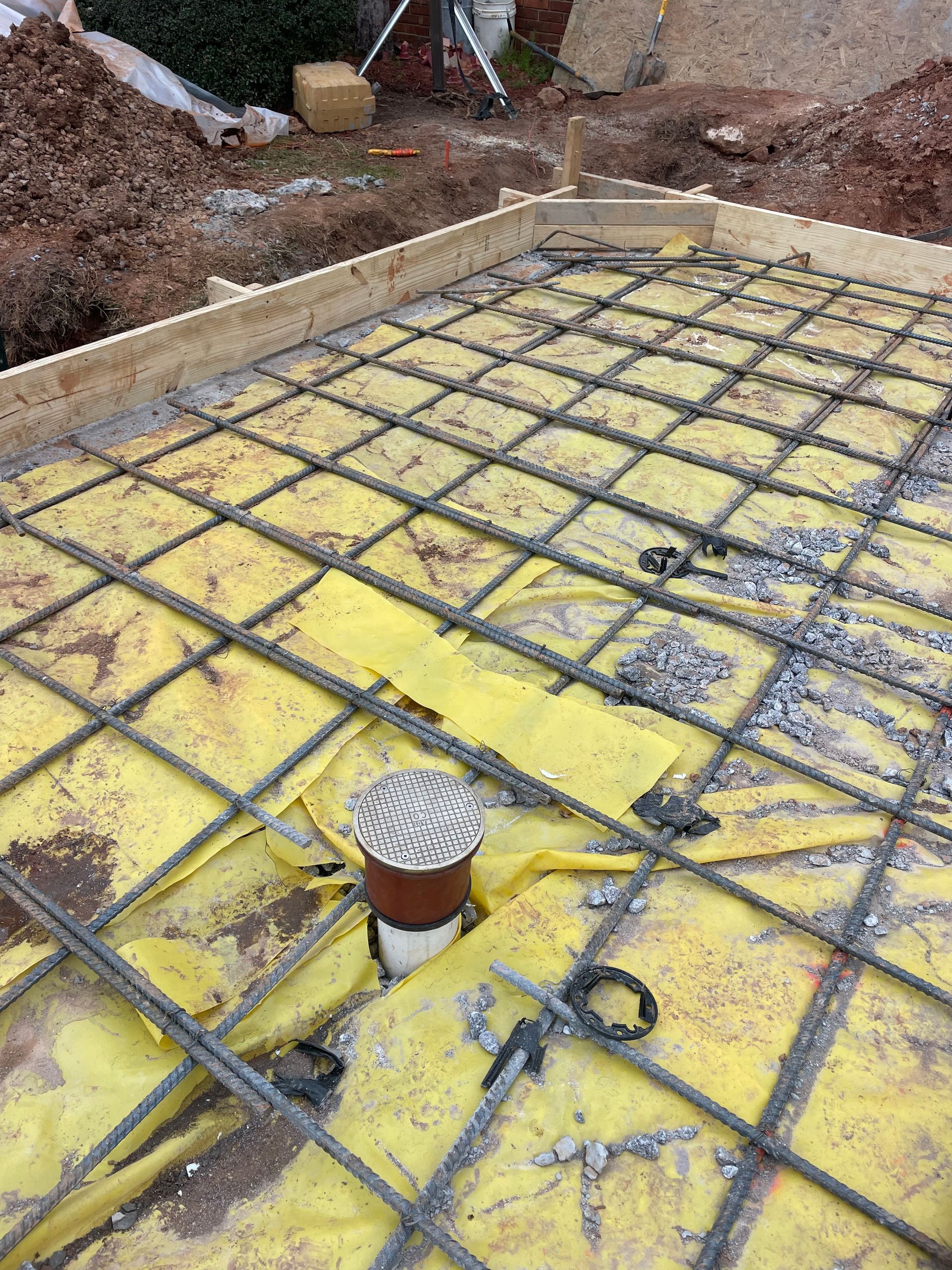 A drain is sitting on top of a concrete floor.