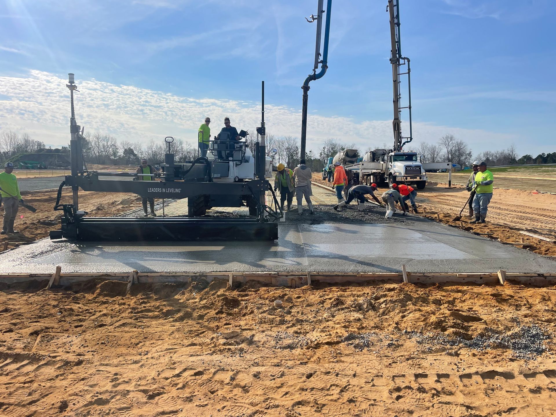 A group of construction workers are working on a concrete slab.
