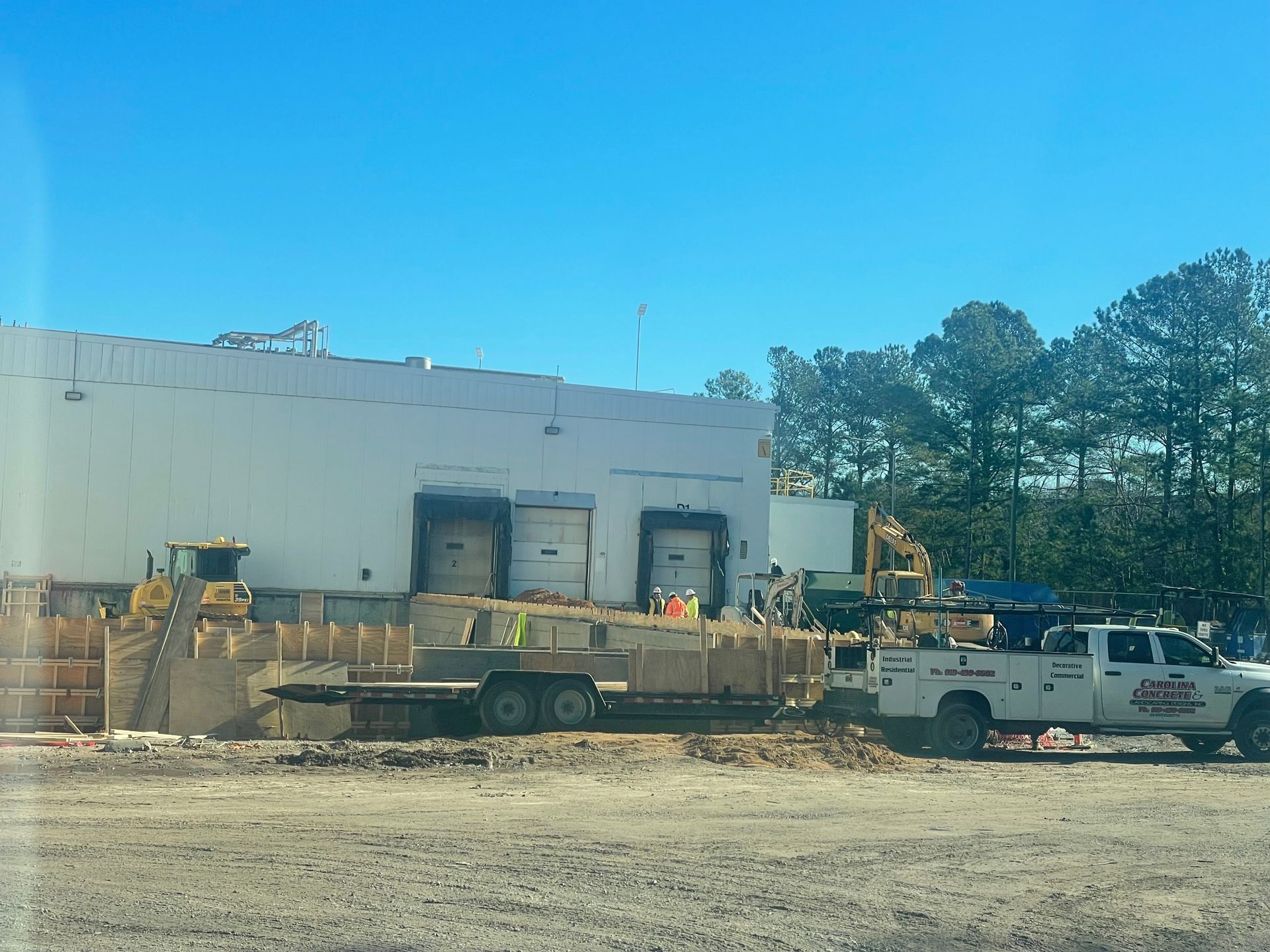 A white truck is parked in front of a building under construction