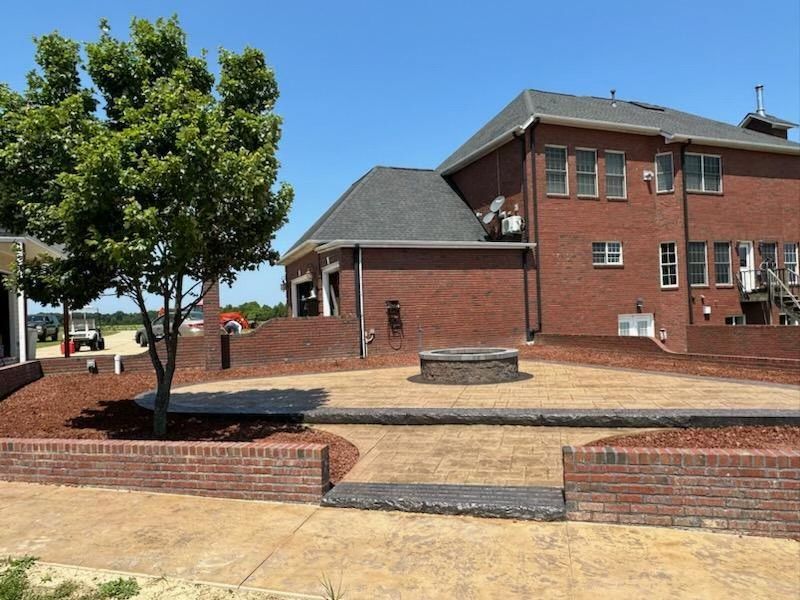 A large brick house with a tree in front of it.