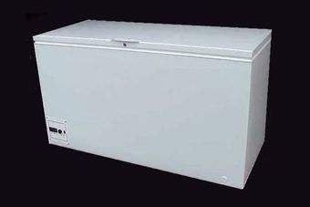 A white chest freezer is sitting on a black background