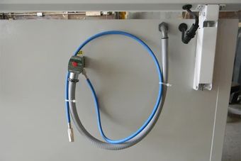 A blue hose is attached to a white freezer