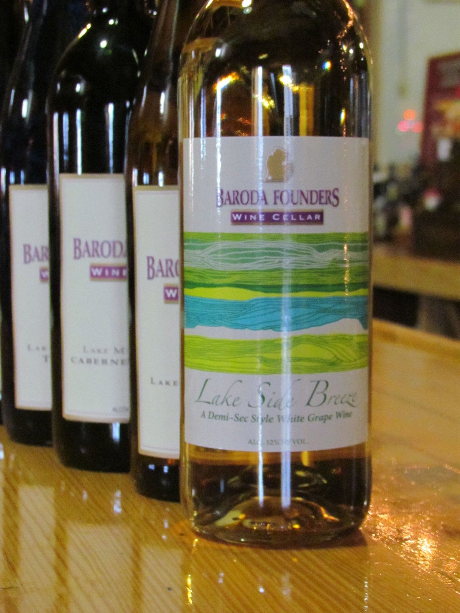 Several bottles of baroda founders wine are lined up on a table