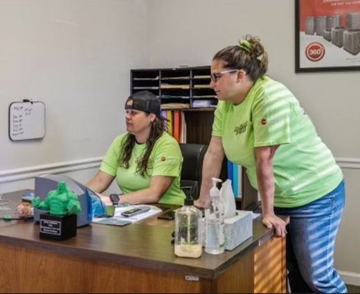 two women wearing green shirts with the word 360 on them