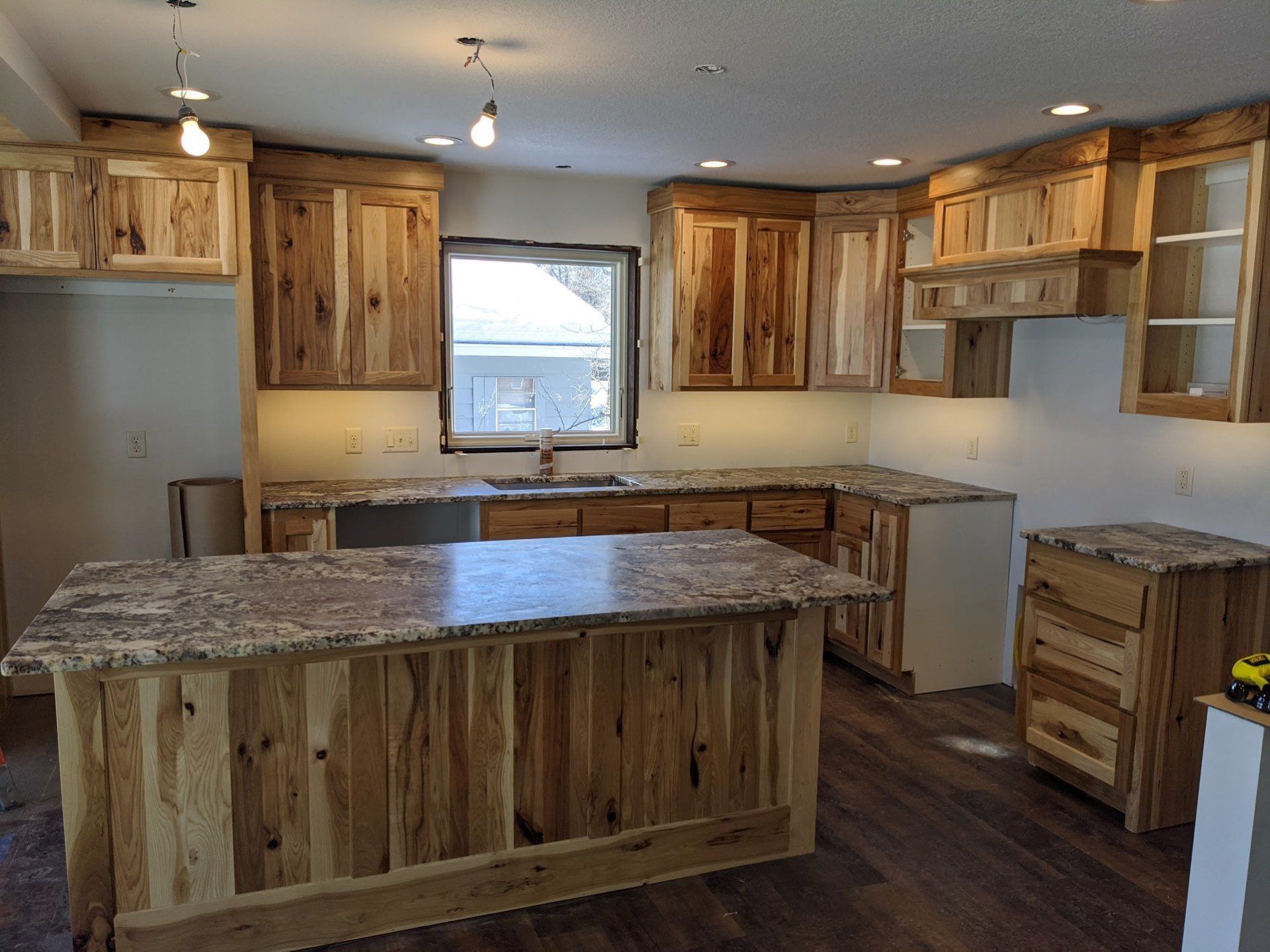 Kitchen with light wood cabinets, granite countertops, and an island.
