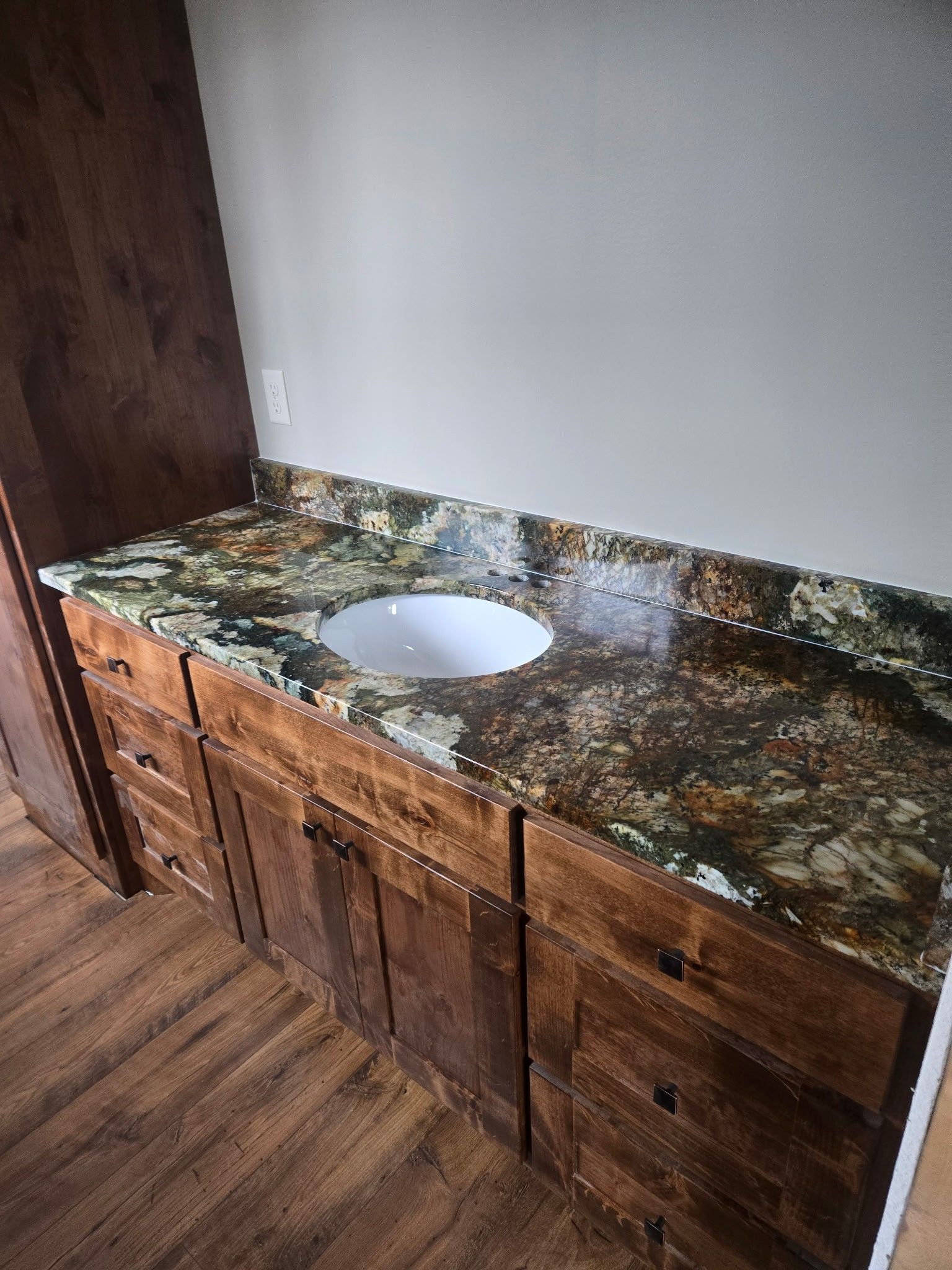 A kitchen with wooden cabinets and granite counter tops.