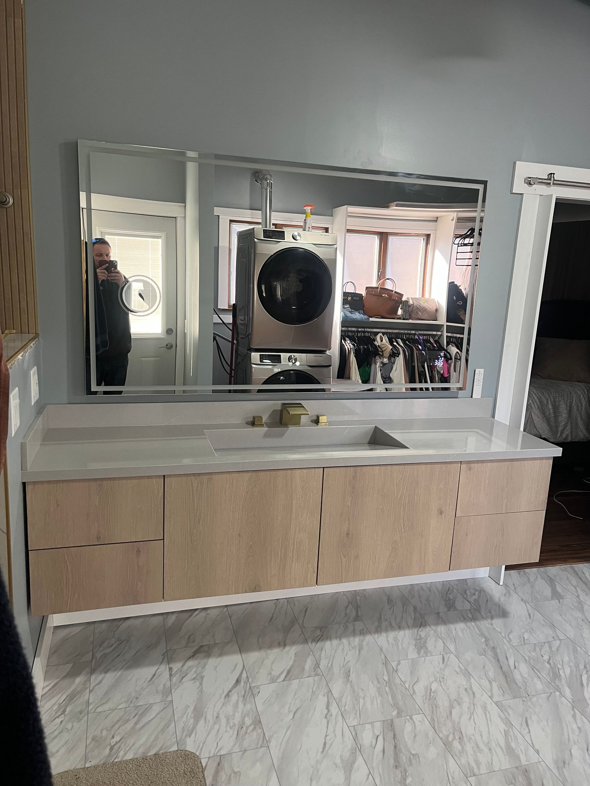 A bathroom with a large mirror and a sink