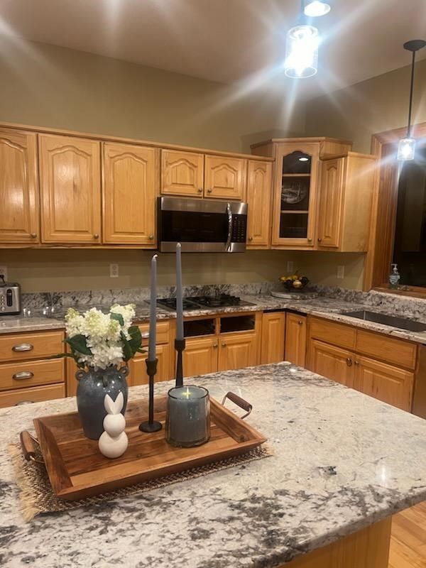 a kitchen with a granite counter top and wooden cabinets .