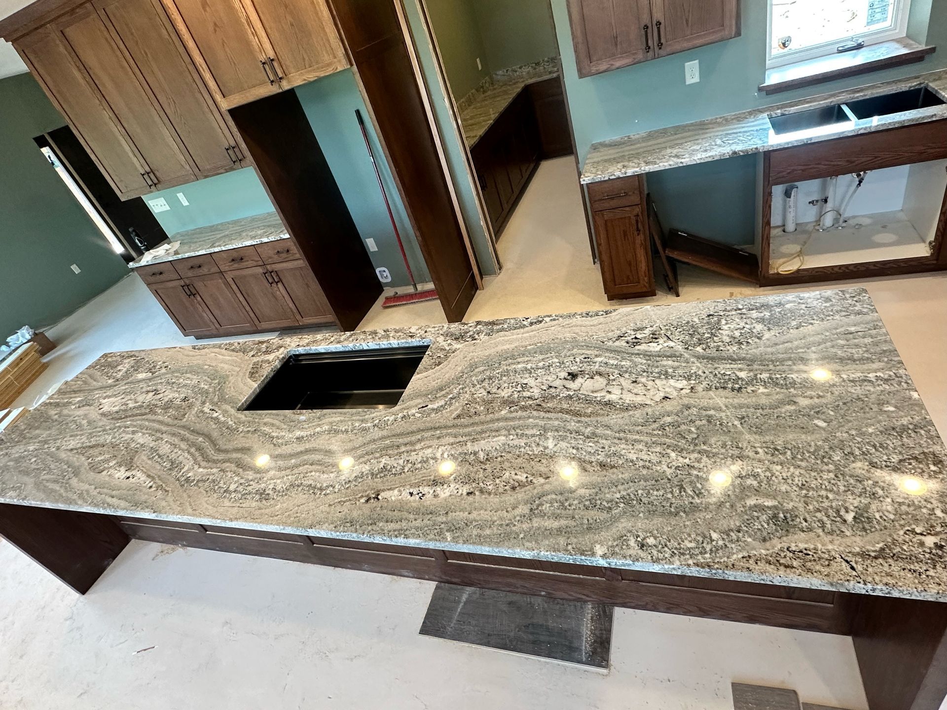 A kitchen with a large granite countertop and a sink
