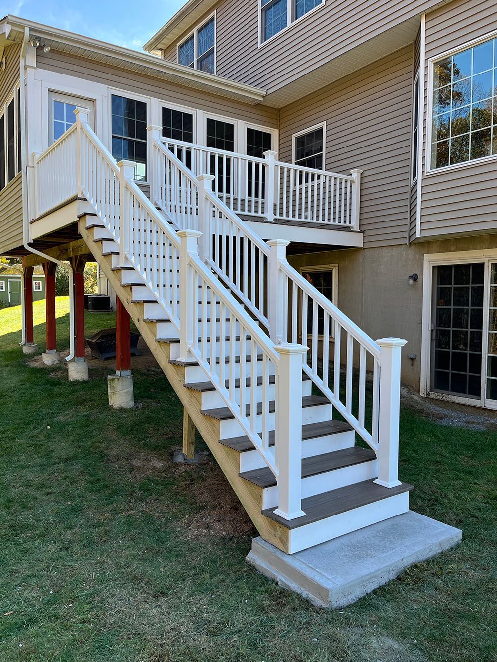 A house with a deck and stairs leading up to it.